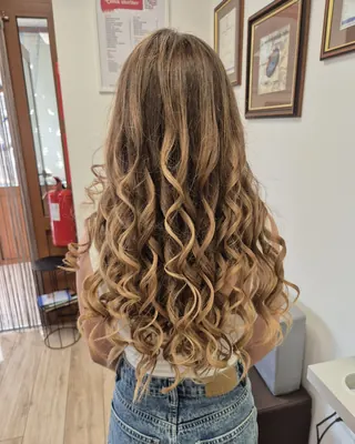 Dolgi kodrasti lasje z balayage v medenih tonih