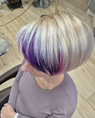 Platinasto blond bob z vijoličnim pramenom ob obrazu