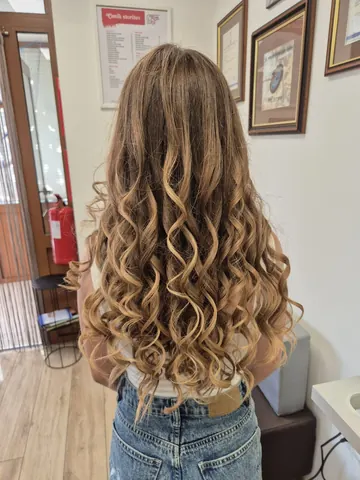 Dolgi kodrasti lasje z balayage v medenih tonih